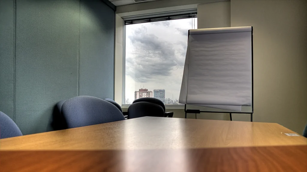 Meeting room with a wooden table and a flipchart