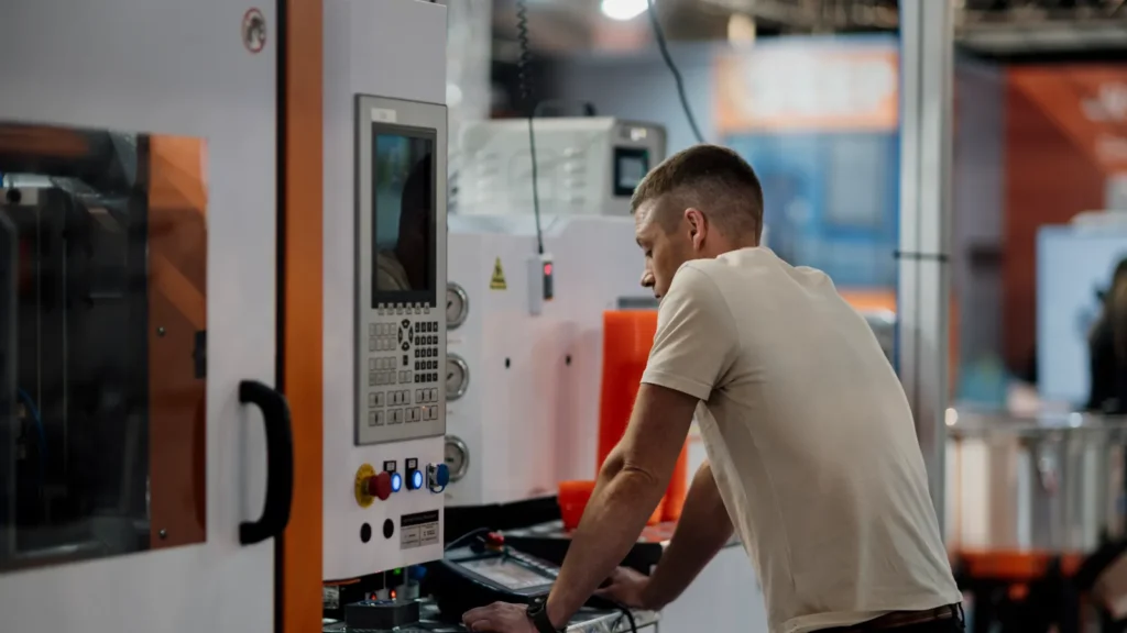 Visitante operando máquina industrial em estande de feira