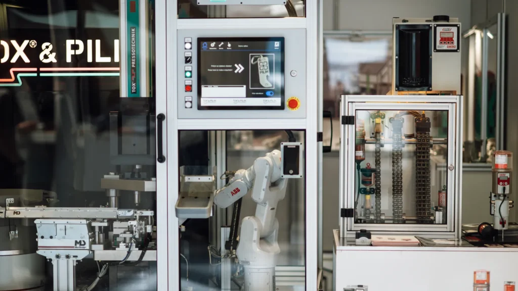 Braço robótico operando uma máquina em uma fábrica